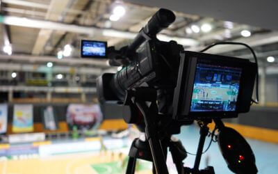 Billed af et videokamera, der filmer ud i en sportshal.