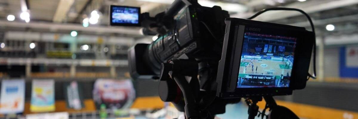 Billed af et videokamera, der filmer ud i en sportshal.